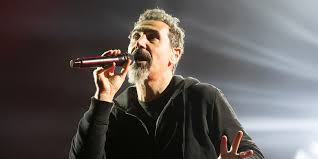 A close-up photo of Serj Tankian and Daron Malakian from System of a Down, with a focus on their facial expressions that hint at disagreement.